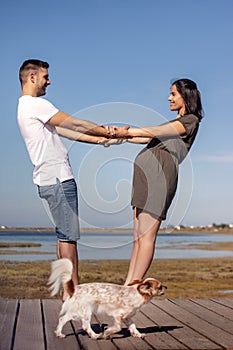 Pregnant happy couple with small dog