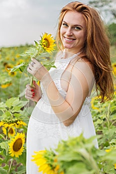 Pregnant happy girl in sunflowers field