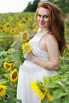 Pregnant happy girl in sunflowers field