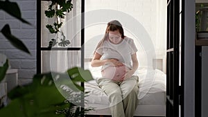Pregnant happy morning expectant mother wake up caressing her belly. Woman hands touching her tummy, waiting child