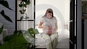 Pregnant happy morning expectant mother wake up caressing her belly. Woman hands touching her tummy, waiting child