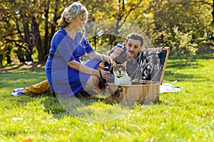 Pregnant happy and smiling couple on picnic with cat