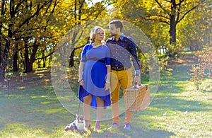 Pregnant happy and smiling couple on picnic with cat