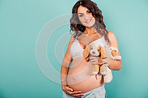 Pregnant happy woman expecting a child caresses her belly