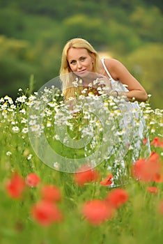 Pregnant happy woman in a flowering poppy field outdoors