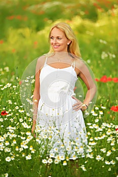 Pregnant happy woman in a flowering poppy field outdoors