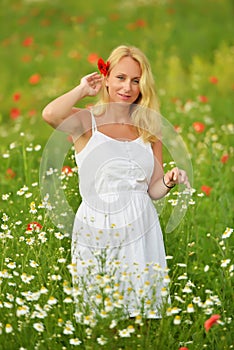 Pregnant happy woman in a flowering poppy field outdoors