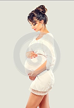 Pregnant happy woman touching her belly. Pregnant beauty young mother portrait, caressing her belly and smiling. Healthy pregnancy