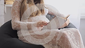 Pregnant Happy Woman using Tablet computer and touching her Belly. Mom Expecting Baby