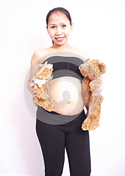 Pregnant happy young lady holding two teddy bears on white background