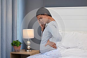 Pregnant, headache and back pain of a woman in her home bedroom thinking about stress or anxiety. Person on bed with