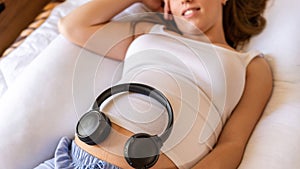 Pregnant headphones music. Pregnancy woman listening to music. Mother belly listen headphones sound. Concept maternity