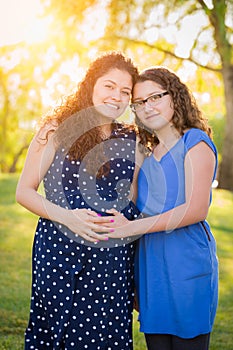 Pregnant Hispanic Mother and Her Daughter Portrait In Rural Setting