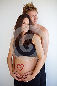 Pregnant, hug and portrait of couple with heart on stomach for love, care and support on white background. Family
