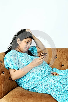 Pregnant irritate woman is holding medicine in hand