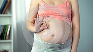Pregnant lady showing ok sign, prenatal care, healthy baby in third trimester photo