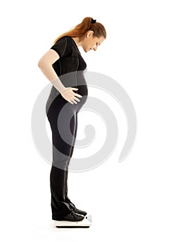 Pregnant lady weighing oneself photo