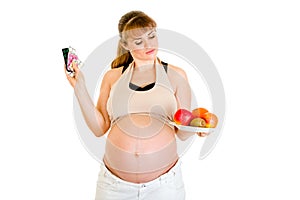 Pregnant making choice between pills and fruits