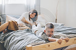 Pregnant mom playing with child in bedroom