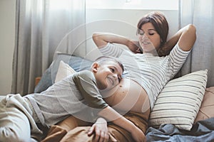 Pregnant mom playing with child in bedroom