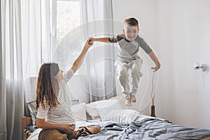 Pregnant mom playing with child in bedroom