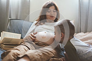 Pregnant mom playing with child in bedroom