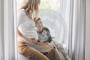 Pregnant mom playing with child in bedroom