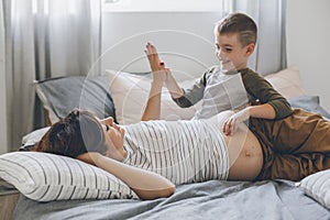 Pregnant mom playing with child in bedroom
