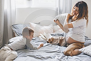 Pregnant mom playing with child in bedroom