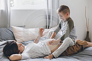 Pregnant mom playing with child in bedroom