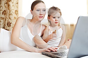 Pregnant mother and child with laptop computer