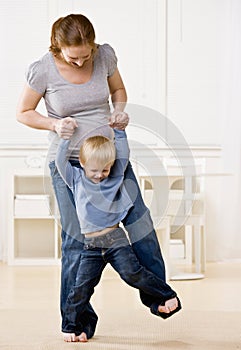 Pregnant mother dances with her son on her feet