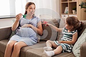 Pregnant mother and daughter with crane origami