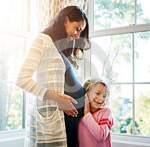 Pregnant, mother and daughter with listening to stomach for baby kick, excited for newborn and curious with smile in