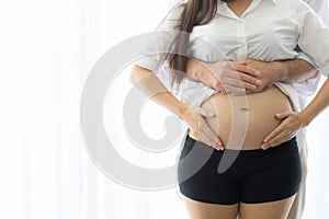 Pregnant Mother and father standing hugging holding belly, family concept.