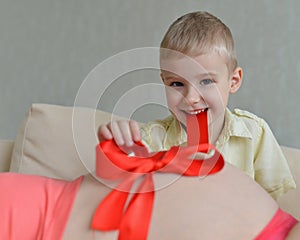 Pregnant mother with her cute little boy on the sofa