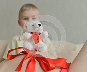 Pregnant mother with her cute little boy on the sofa