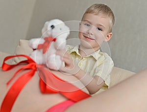 Pregnant mother with her cute little boy on the sofa