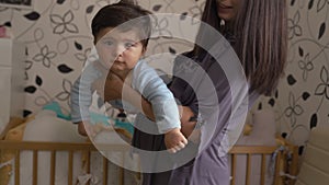 Pregnant Mother holding playing with her baby son talking with him - Asian mixed ethnicity child Boy wearing blue body