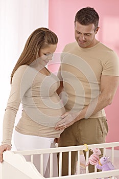 Pregnant mother and husband in baby's room