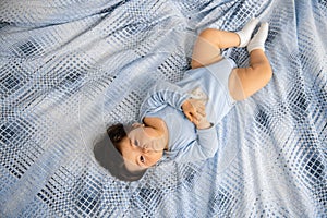 Pregnant Mother laying with her baby son on the bedroom bed playing and having fun - Asian mixed ethnicity child Boy