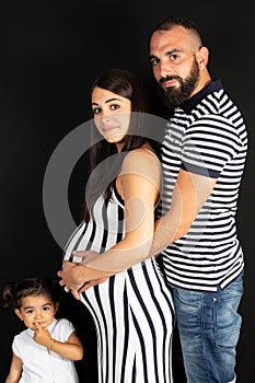 Pregnant mother lifestyle with daughter and father in black background
