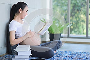 A pregnant mother reads a story to her unborn child. An expectant mother is reading a book on parenting