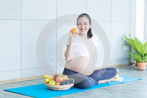 The pregnant mother is showing food and fruit to nourish the pregnancy