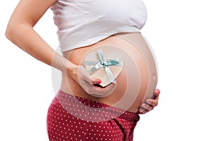 Pregnant mother showing her belly and holding a gift