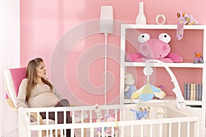 Pregnant mother sitting in baby's room