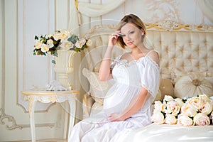 Pregnant mother sitting on a bed of roses