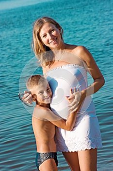 Pregnant mother and son hugging