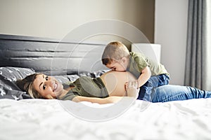 A Pregnant mother and son spending time together in bedroom