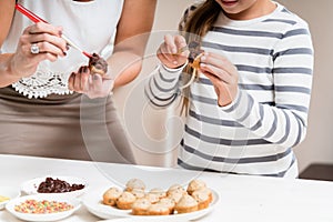 Pregnant mum and her little daughter baking together